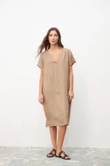 Vestido color beige de lino, corte recto, con cuello en V y mangas cortas.