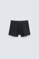 Pack de tres calzoncillos tipo bóxer en gris claro, gris oscuro y negro, con cintura elástica.