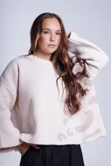 Sweater negro de tejido de punto con cuello redondo y estampado abstracto en color beige en la parte superior delantera y en una manga.