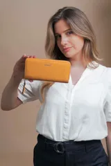 Billetera larga color beige de símil cuero, con cierre perimetral y bolsillo trasero con cierre.