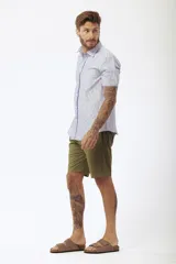 Camisa blanca de manga corta con cuello clásico y cierre frontal con botones.