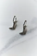 Aros dorados de acero quirúrgico hipoalergénico con dije colgante en forma de bota texana con detalles calados.