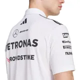 Polo oficial de adidas Motorsports del equipo Mercedes-AMG Petronas Formula One Team, color blanco, con cuello polo y cierre de botones. Presenta franjas negras en los hombros y múltiples logos de patrocinadores en el pecho y mangas.