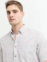 Camisa de manga corta a rayas verticales celestes y blancas, con cuello abotonado y corte clásico.