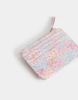 Billetera pequeña de cuerina estampada con flores de colores. Tiene cierre superior con tirador rosa, lazo con broche a presión y compartimentos para tarjetas.
