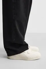 Zapatillas deportivas negras con triple cierre adherente, combinación de piezas en el corte y suela con ligero volumen. Diseño de inspiración retro.