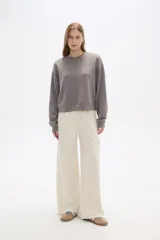 Pantalón negro de poliéster, de calce alto y corte ancho, con bolsillos laterales y cintura elástica.