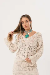 Saco color crudo de crochet con botones y mangas largas.