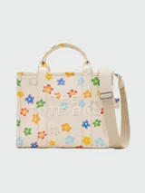 Bolso tote mediano de lona color crema con estampado de margaritas de colores, doble asa corta y correa larga extraíble.