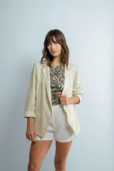 Blazer estilo sastrero color dorado con acabado satinado, con corte clásico y mangas largas.