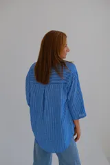 Blusa de mangas 3/4 con cuello en V y estampado a rayas verticales azules y blancas.