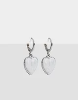 Aros dorados tipo argolla con dije colgante en forma de corazón blanco con diseño marmolado.