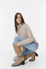 Bota alta de color visón, con tacón cuadrado y diseño elegante.