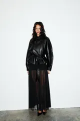 Cazadora negra de efecto piel, con cuello solapa y manga larga acabada en puño. Tiene bolsillos de vivo en delantero, cinturón lazada en mismo material y bajo acabado peplum. El cierre frontal es con cremallera.