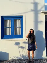 Minifalda dorada de cuero sintético, corte medio/bajo, con cortes en el delantero y pequeño tajo a un lado.