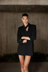 Blazer blanco con cuello solapa y hombreras. Manga por debajo del codo acabada en vuelta con trabilla y botón dorado. Bolsillos delanteros con solapa.