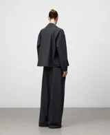 Pantalón de vestir gris melange, tiro alto, con pinzas frontales y pierna ancha y recta.