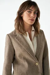 Blazer marrón de lana con solapas de muesca, cierre con dos botones dorados, bolsillos con solapa y forro interior a tono.