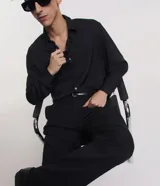 Camisa negra de poliéster con cuello inglés, manga larga, abotonada adelante y textura con rayas verticales.