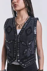 Chaleco negro de jean con bordados y apliques plateados.