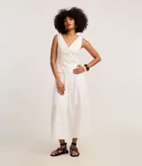 Pollera midi de corte evasé confeccionada en sarga de algodón blanco. Presenta un diseño con recortes verticales y nesgas que aportan volumen en el ruedo, cintura ajustada y largo por debajo de la rodilla.