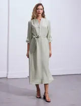 Vestido maxi color beige, con cuello mao, mangas 3/4 con presilla y lazo en la cintura.