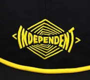 Gorro negro de cinco paneles con visera plana, logo de Independent bordado en amarillo en el frente y cordón amarillo sobre la visera.
