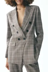 Blazer de Zara Woman Collection, con cuello solapa y manga larga. Tiene bolsillos delanteros y cierre cruzado con botones.
