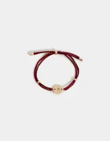 Pulsera de cordón ajustable color borgoña con hilo dorado, con dije circular dorado con la inscripción "Lucky Good".