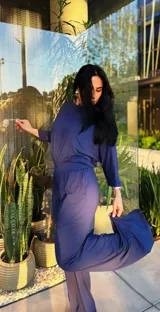 Pantalón de vestir color azul marino, de corte recto, con bolsillos laterales y traseros. Se ajusta a la cintura con cinturón de cuero marrón.