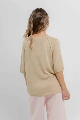 Buzo de punto color beige, de manga 3/4, calce relajado y escote redondo.