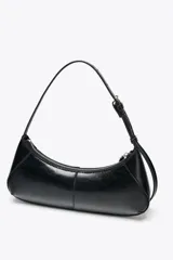 Bolso de hombro negro de cuero sintético, con asa ajustable con hebilla metálica, bolsillo interior con cremallera y cierre principal con cremallera.
