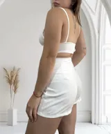Short de vestir color blanco con corte de pollera cruzada y lazo lateral con hebilla metálica.