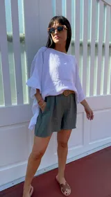 Short color verde militar de lino, con cintura alta y cinturón de rafia con hebilla circular.