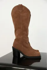 Bota alta de color visón, con tacón cuadrado y diseño elegante.