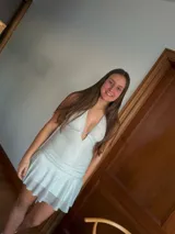 Vestido corto con lentejuelas color verde esmeralda, escote en V profundo y espalda descubierta.