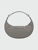 Bolso bandolera pequeño de cuero color gris con forma de media luna, cierre superior con cremallera y botón a presión, correa de cuero ajustable y extraíble, y herrajes plateados.