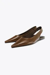 Zapato destalonado tipo bailarina, color marrón, de piel, con punta fina y tira trasera con elástico lateral.