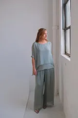 Pantalón palazzo verde agua, de tela fluida y cintura alta con elástico.