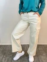 Pantalón cargo color beige de eco cuero, corte recto y bolsillos laterales.