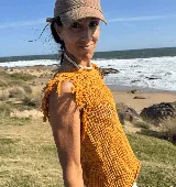 Musculosa tejida color marrón con diseño calado y flecos en los hombros.