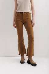 Pantalón jean marrón acampanado con detalle desflecado en el bajo y tiro medio.
