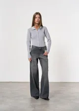 Pantalón de jean gris oscuro, de tiro medio y corte wide leg.