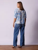 Blusa de gasa estampada con flores blancas sobre fondo celeste, marca Floral & Ivy. Cuello a la base con escote en V. Manga corta con detalle de puño y botón.