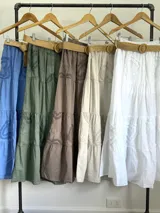 Falda larga de estilo campesino color crudo, confeccionada en algodón italiano con apliques florales al tono. Tiene cintura elastizada y cinto de rafia elastizado desmontable.