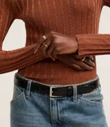 Suéter negro de punto con cuello redondo y mangas largas. Presenta rayas verticales texturizadas y tejido con hilos metalizados.