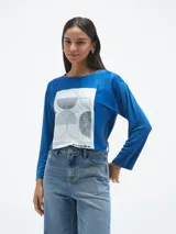 Blusa azul con estampado abstracto en blanco y negro, de mangas largas.