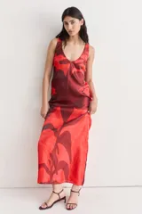 Vestido largo de seda con escote redondo y estampado abstracto en tonos rojo y marrón.