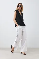 Chaleco negro con cuello en V y cierre frontal con botones. Confeccionado en lino.