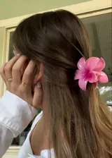 Pinza para el pelo color rosa con forma de flor.